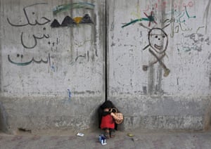 An Afghan girl who sells pens sleeps along a street in Kabul