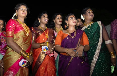 A group of women in brightly coloured saris stand together
