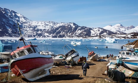 A man walks to his boat past boats in the town of Tasiilaq, Greenland