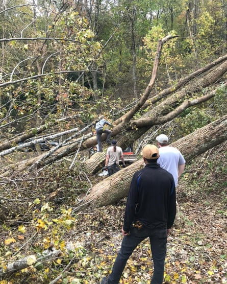 people working to move fallen trees