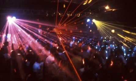 Pink, red and yellow laser lights over a dancing crowd