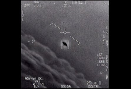 A blurry black-and-white photograph of a cockpit display showing a mysterious dark object in the centre of the frame