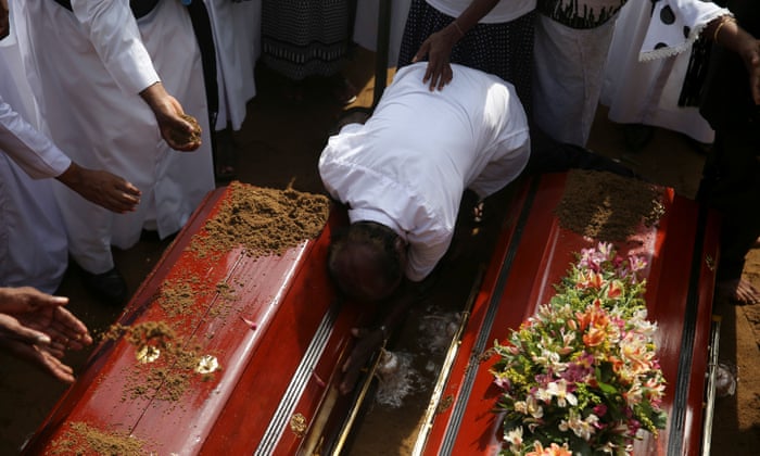 A man reacts during a mass burial of victims at a cemetery near St Sebastian Church.