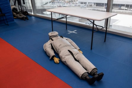A dummy lying on the fall with a table behind it