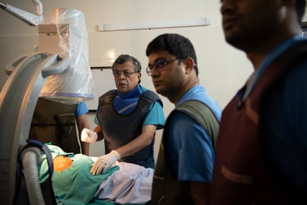 Dr GP Dureja performs a procedure on a patient in the operation theatre at the Delhi Pain Management Centre.