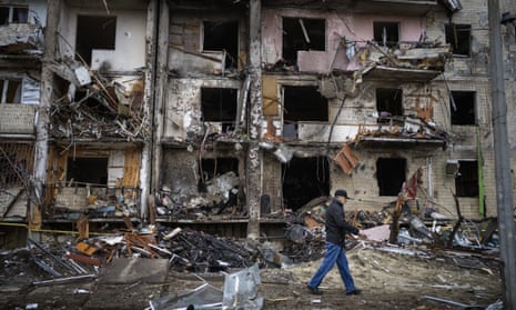A man walks past a war-damaged building in Kyiv