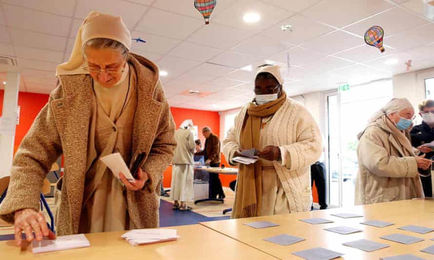 Franciscan nuns from the order of Saint Clare collect their ballots at a polling station in Cormontreuil, north-east France