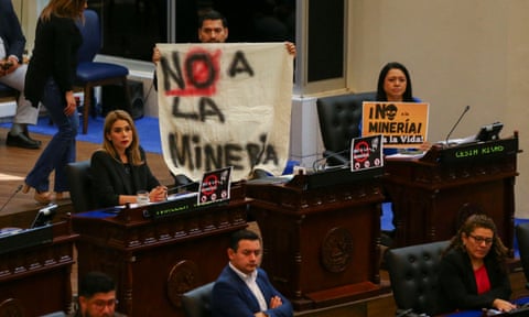 People in Congress hold up signs that say "No Mineria"