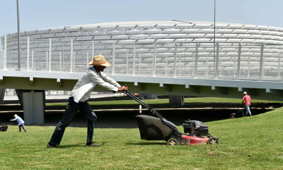 Gardeners cut the grass in front of Azerbaijan’s Olympic Stadium, which seats around 68,000 although Baku airport can only deal with around 15,000 arrivals a day.