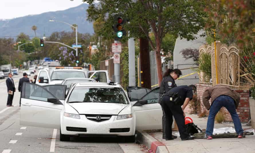Investigators work a crime scene around a white Acura vehicle after the arrest of a man found with assault weapons and possible explosives in Santa Monica.
