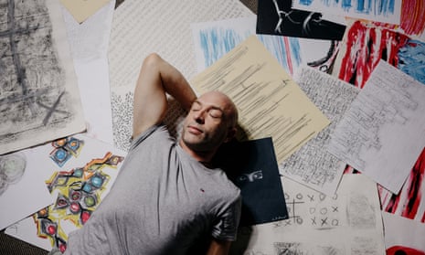 Lee Hadwin lying down on some of his drawings