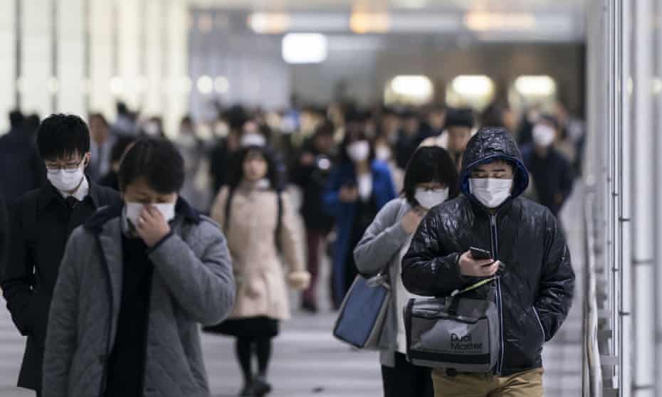 Pedestrians wearing face masks walk through an underground passage on in Tokyo, Japan