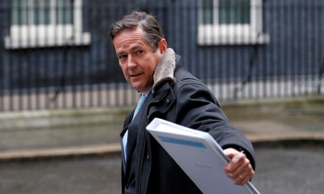Jes Staley in Downing Street, looking over his shoulder and gesturing towards someone with one hand, in which he is holding a white ring binder