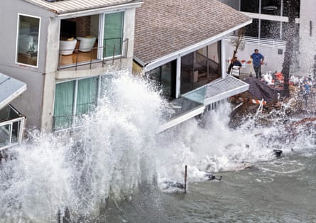 a wave crashing into homes