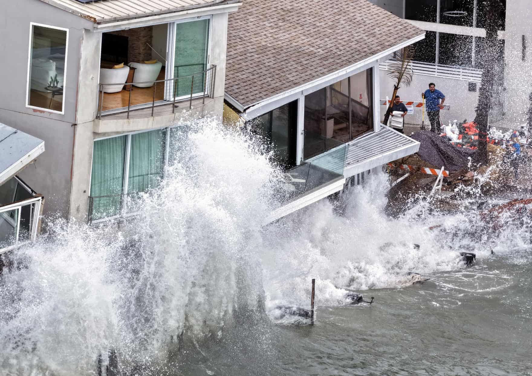 Dalğalar Long Beach-də evlərə və dəniz divarına çırpılır. Fotoqraf: Mario Tama/Getty Images