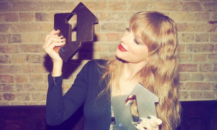 Taylor Swift holding two awards