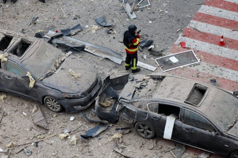 An emergency worker talks on phone at an impact site in a residential neighbourhood after Russian drone and missile attacks in Kyiv.