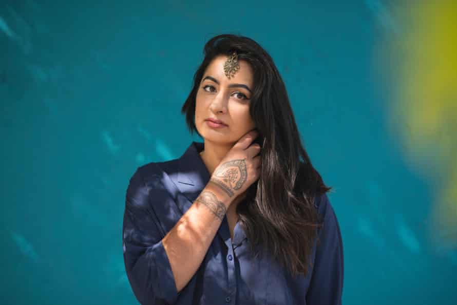 A portrait of Sharan Dhaliwal against a teal blue background.