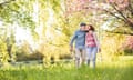 Beautiful senior couple in love outside in spring nature.<br>Beautiful senior couple in love on a walk outside in spring nature under blossoming trees.