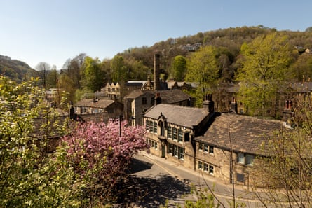 Trees and stone buildings, one with a chimney, in a valley.