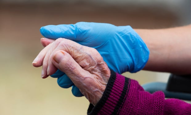 Carer hold a resident's hand