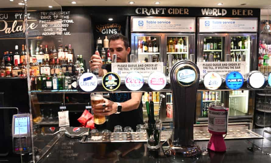 Barman pulls a pint in a pub.