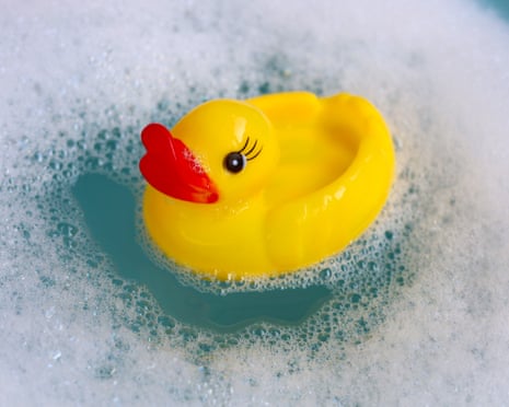 Small yellow duck toy in soapy bubbles.