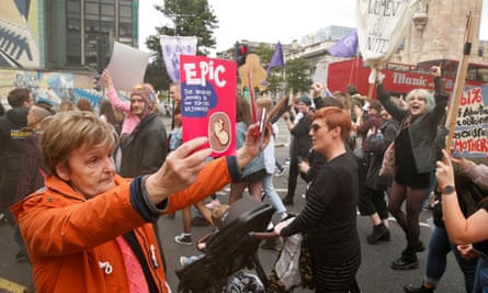 An anti-abortion supporter holds up leaflets as pro-choice demonstrators march in Belfast in September