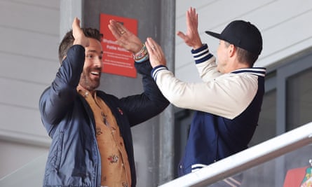 Wrexham co-owners Ryan Reynolds (left) and Rob McElhenney high-five each other at a match in April 2023