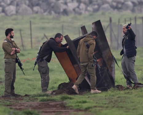 Israeli soldiers inspect the remains of an Iranian ballistic missile in the Golan Heights