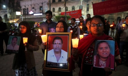 Survivors and relatives of victims of the Bhopal gas accident hold photos of the victims during a candlelight vigil.
