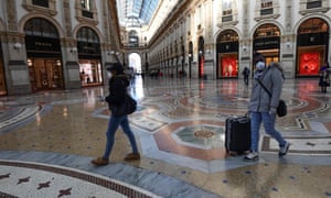 Tourists wearing protective face masks walk in Galleria Vittorio Emanuele II in the centre of Milan.