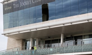 Workers clear up after a window fell out of the Champions Gallery on the third floor on to the level two seating at Newmarket.
