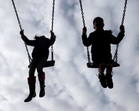 Children enjoy playing on swings in a park near Ashford, Kent.