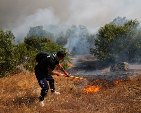 A volunteer uses a rake trying to help stop a wildfire from advancing in San Martin de Valdeiglesias, west of Madrid, Spain.