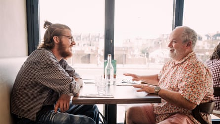 Two men facing each other across a restaurant table
