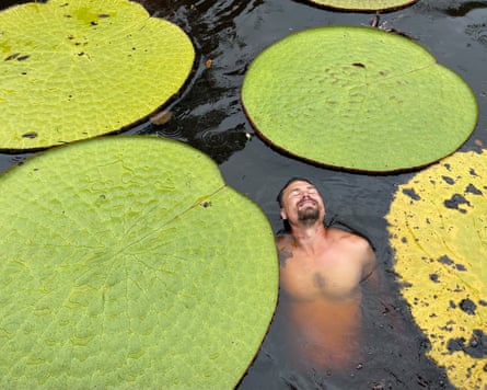 Jeremiah Harris in the water beside giant waterlilies