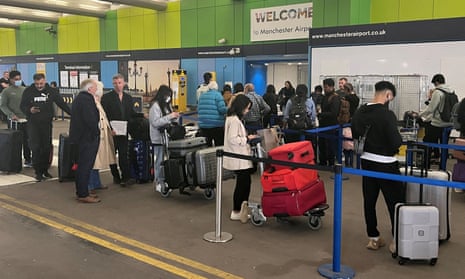 Passengers queue at a check-in desk at Manchester airport last summer.