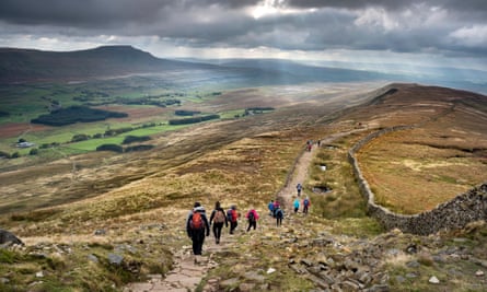 Walkers descend the path from Whernside.