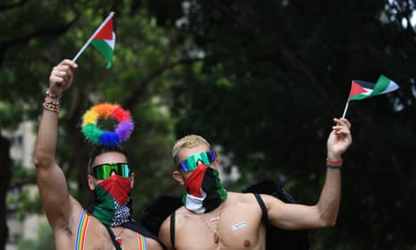 People wave Palestinian flags during the 46th annual Sydney Gay and Lesbian Mardi Gras Parade in Sydney, Saturday, March 2, 2024. (AAP Image/Steven Saphore) NO ARCHIVING