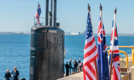 National flags of the USA, Australia and Great Britain are seen in front of the USS Asheville, a Los Angeles-class nuclear powered fast attack submarine
