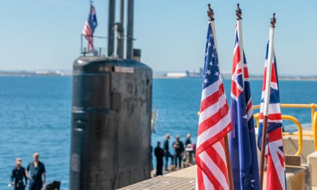National flags of the US, Australia and the UK in front of the USS Asheville, a Los Angeles-class nuclear-powered fast attack submarine, at HMAS Stirling in WA