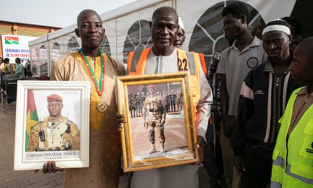 Supporters of Burkina Faso president Ibrahim Traore hold photographs of Traore at a donation ceremony in Ouagadougou in January to receive Russian wheat
