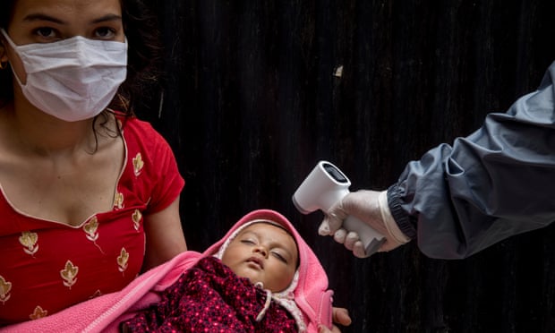 A health worker checks the temperature of a child during a national vaccination campaign in Kathmandu, Nepal.