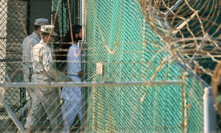 US military guards moving a detainee inside Camp Delta in Guantánamo Bay