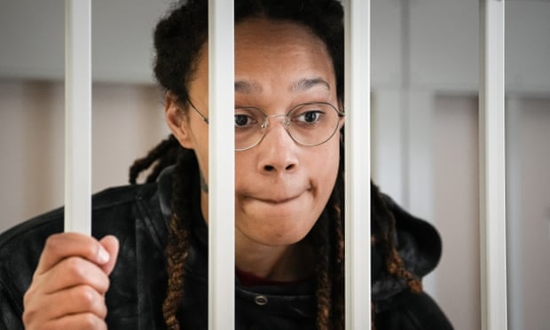 Brittney Griner speaks to her lawyers standing in a cage at a courtroom prior to a hearing in Khimki, Russia on 26 July.