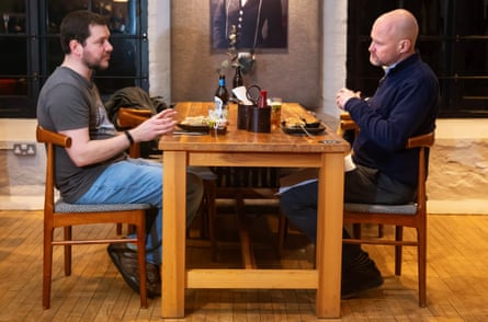 Two men facing each other across a restaurant table