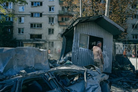 Oleksandr, a car park attendant, near damaged cars and booth in the car park after the blast