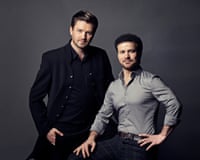 Two men posing against a grey backround