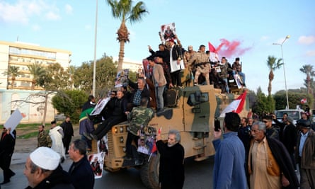 Supporters of Libyan National Army in Benghazi celebrate on top of a Turkish military armoured vehicle, which the LNA said it confiscated during clashes in Tripoli.